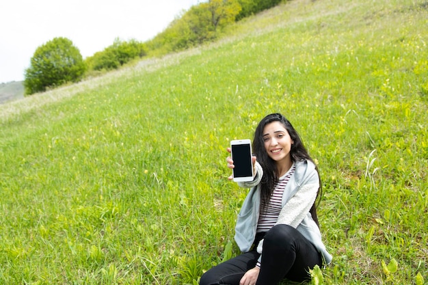 Gelukkige vrouw hand telefoon in landschap