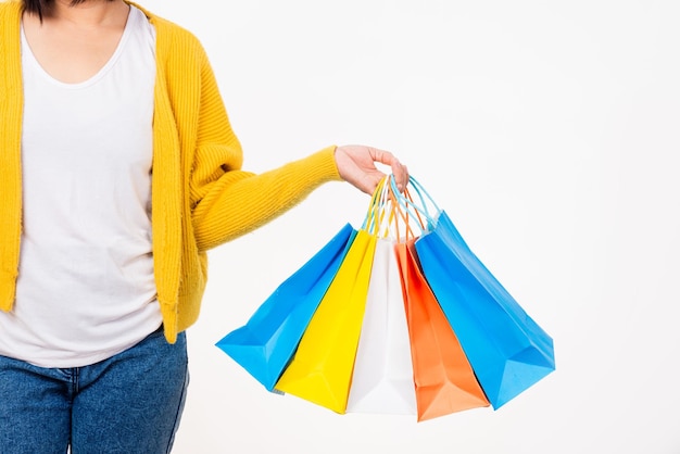 Gelukkige vrouw hand ze draagt geel shirt met winkeltassen veelkleurige jonge vrouw houdt veel pakketten in haar armen geïsoleerd op witte achtergrond Black Friday verkoopconcept