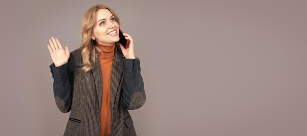 Gelukkige vrouw in casual mode-stijl praten op mobiele telefoon grijze achtergrond kopie ruimte gesprek Vrouw portret geïsoleerde header banner met kopie ruimte