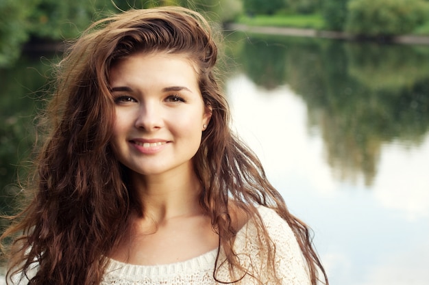 Gelukkige vrouw in de buurt van de rivier in de herfst seizoen