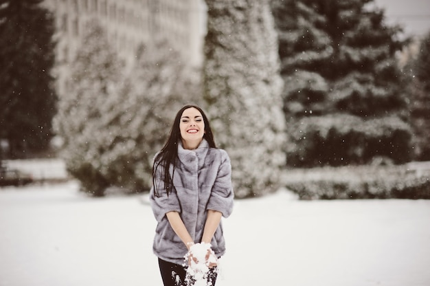 Gelukkige vrouw in een besneeuwde winterdag