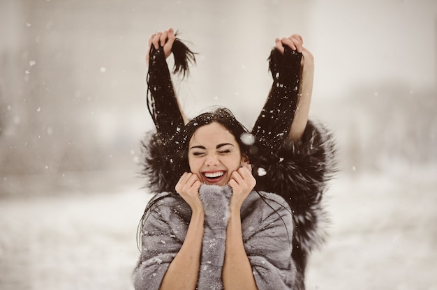 Gelukkige vrouw in een besneeuwde winterdag