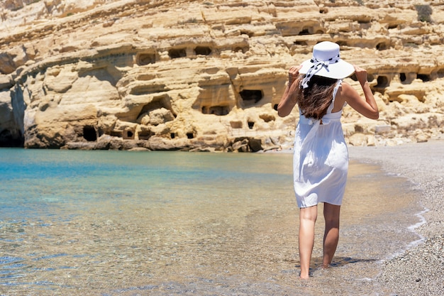 Foto gelukkige vrouw in een hoed op een tropisch strand