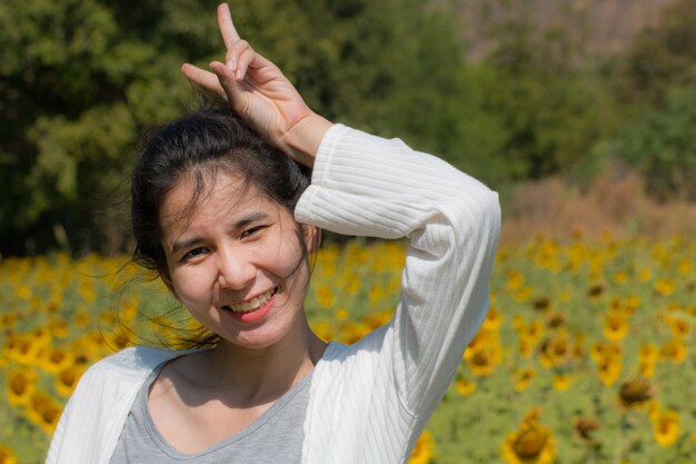 Gelukkige vrouw in gebiedszonnebloemen op zonnige dag