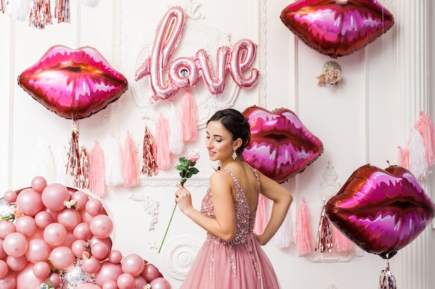 Gelukkige vrouw in tule jurk met roze ballons. luxe