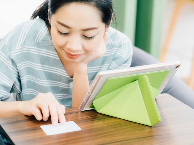 Gelukkige vrouw is met behulp van creditcard