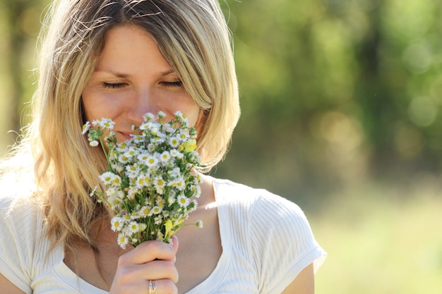 Foto gelukkige vrouw met bloemen in liefde buiten spelen in het park