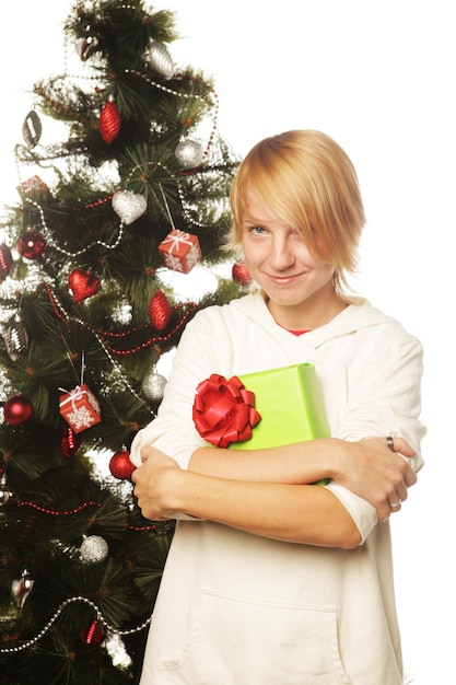 Gelukkige vrouw met geschenkdoos en kerstboom