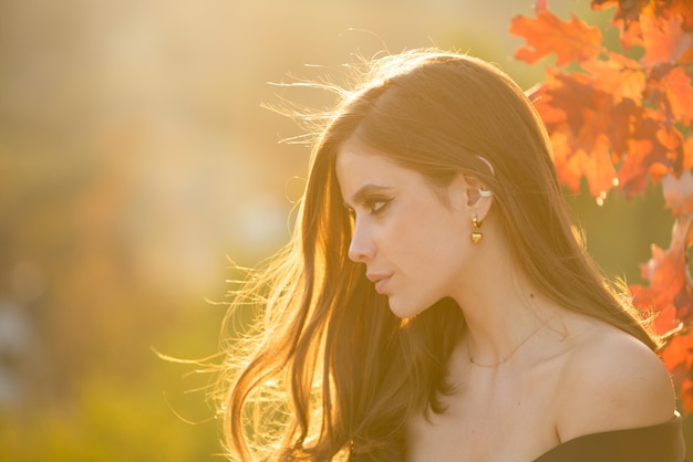 Gelukkige vrouw met herfbladeren op haar gezicht in de herfst natuur portret van jonge vrouw met herfst esdoorn le