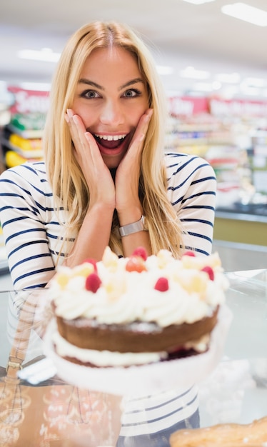 Gelukkige vrouw met mond open voor cake