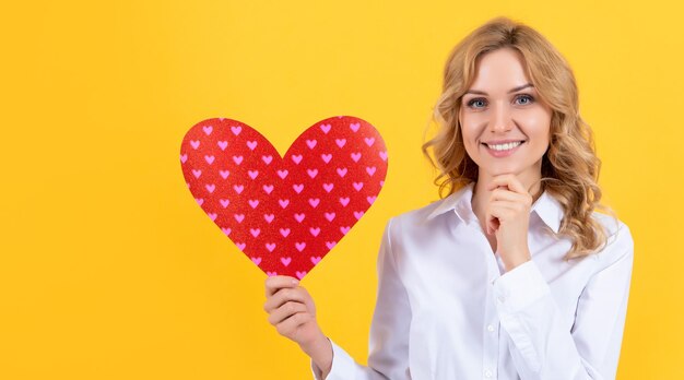 Gelukkige vrouw met rood liefdeshart op gele achtergrond romantisch cadeau