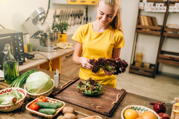 Foto gelukkige vrouw met salade, gezond voedsel koken