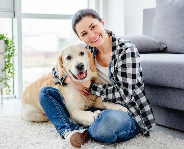 Gelukkige vrouw met schattige hond binnenshuis