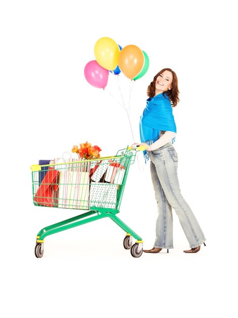 gelukkige vrouw met winkelwagentje en ballonnen over wit