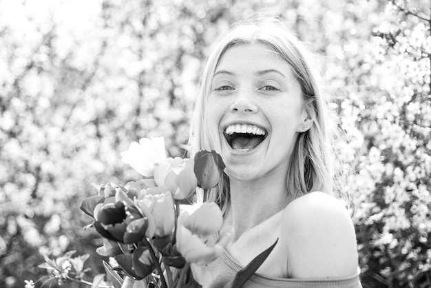 Foto gelukkige vrouw ontspannen in de tulpenvelden women's day maart veld van kleurrijke felrode tulpen