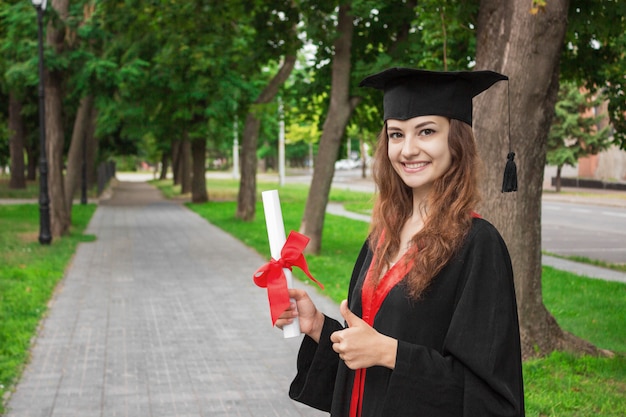 Gelukkige vrouw op haar universiteit van de graduatiedag.