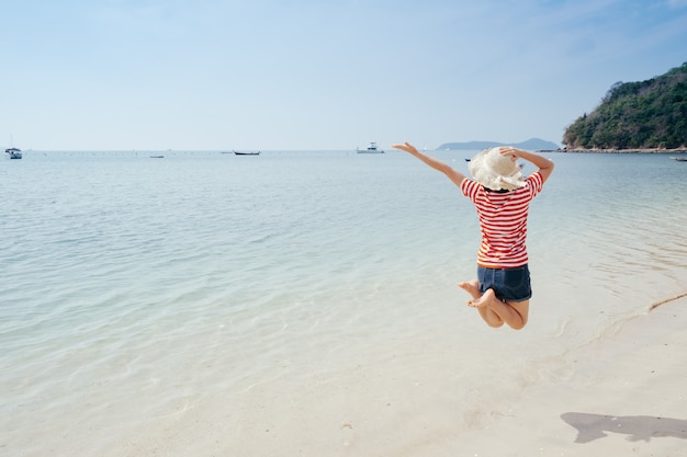 Gelukkige vrouw op het strand en de wolkenhemel.