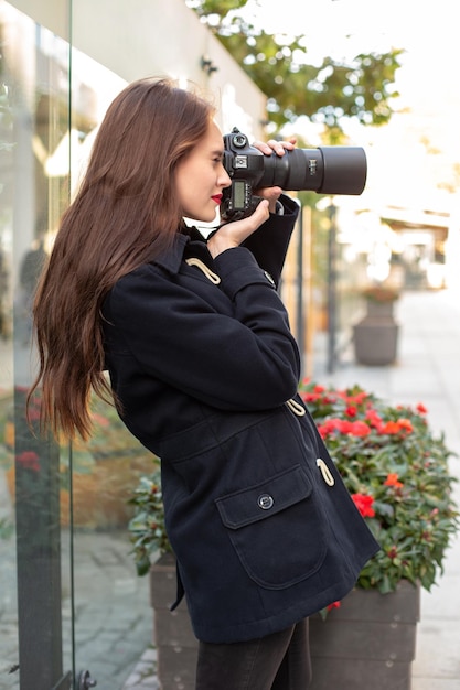 Gelukkige vrouw op vakantie fotograferen met camera op de straat van de stad. plezier hebben in de stad met camera, reisfoto van fotograaf.