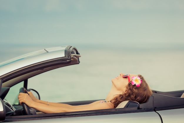 Foto gelukkige vrouw reizen met de auto naar de zee meisje met plezier in cabriolet zomervakantie concept