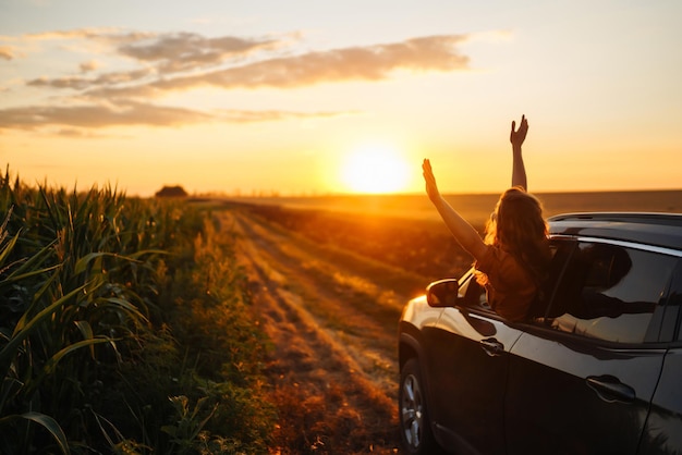 Foto gelukkige vrouw strekt haar armen uit terwijl ze uit het raam van de auto steekt lifestyle reizen toerisme natuur