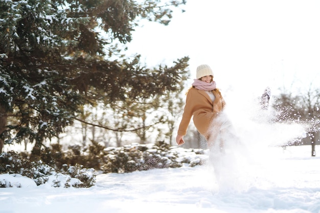 Gelukkige vrouw wandelen in de besneeuwde winterdag buiten Winter mode vakantie rust reizen concept