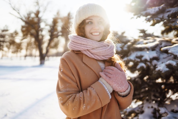 Gelukkige vrouw wandelen in de besneeuwde winterdag buiten Winter mode vakantie rust reizen concept