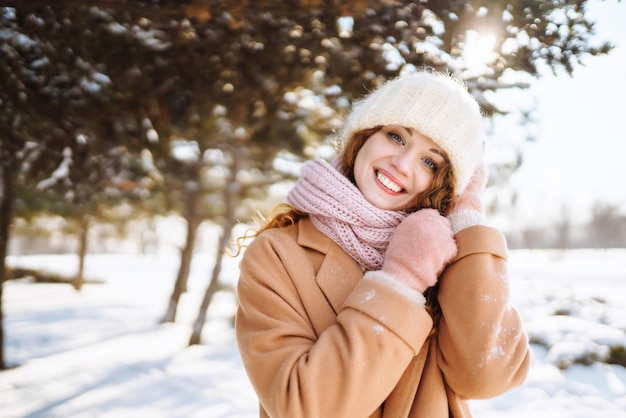 Gelukkige vrouw wandelen in de besneeuwde winterdag buiten Winter mode vakantie rust reizen concept