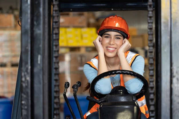 Gelukkige vrouw werknemer magazijnpersoneel heftruckchauffeur blij lachend geniet van het werken van aziatische mensen