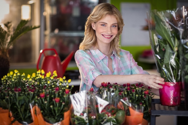 Gelukkige vrouwelijke bloemist die een bloemboeket voorbereidt