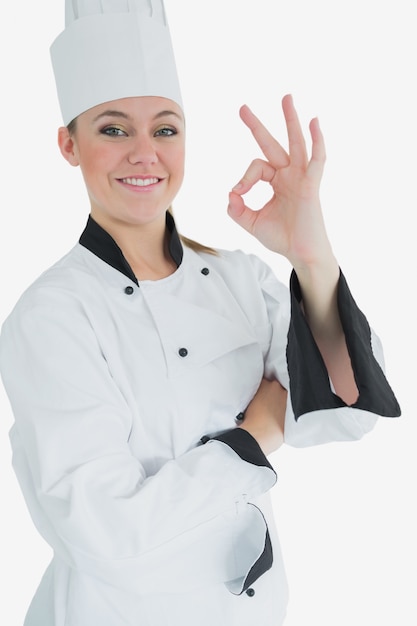 Gelukkige vrouwelijke chef-kok die ok teken gesturing