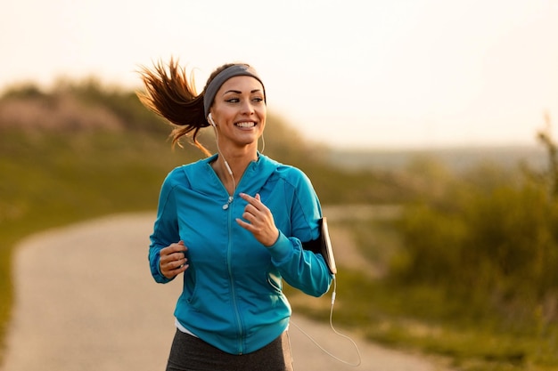 Foto gelukkige vrouwelijke hardloper die 's ochtends in de natuur jogt