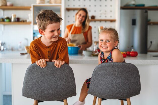 Gelukkige vrouwen die gezond voedsel bereiden en plezier hebben met kind in de keuken. Familie, voedselconcept