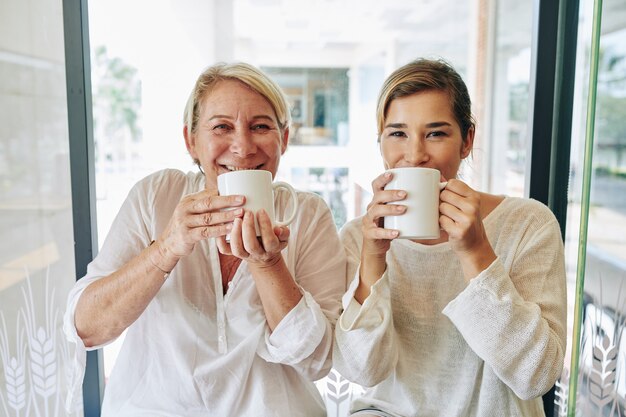 Gelukkige vrouwen die koffie drinken