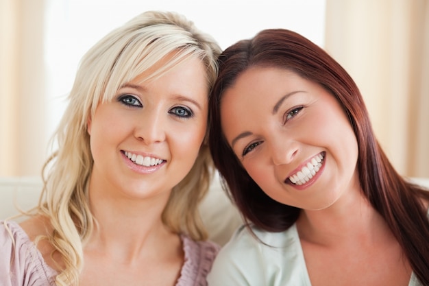 Gelukkige vrouwen die op een bank lounging