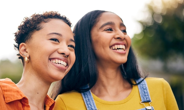 Gelukkige vrouwen glimlachen en vriendinnen in het park met lachen en grappige grap met hechting en roddels buiten Gen z jongeren en glimlachen met vrouwelijke vriendschap vrijheid en vakantie met vreugde op vakantie