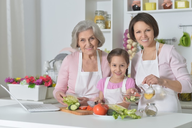 Gelukkige vrouwen met een klein meisje dat in de keuken kookt