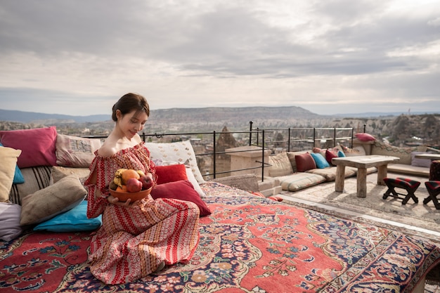 Foto gelukkige vrouwen op dak van holhuis het genieten van van goreme-stadspanorama, cappadocia turkije.