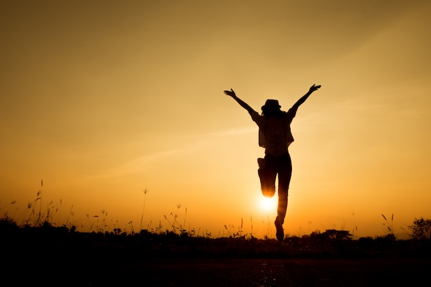 Gelukkige vrouwensprong en zonsondergangsilhouet