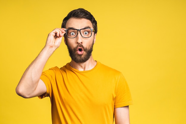 Gelukkige winnaar! Portret van een geschokte, verbaasde jonge mannelijke man houdt de mond wijd open, verrast, drukt grote verbazing uit. Geïsoleerd over roze gele achtergrond.