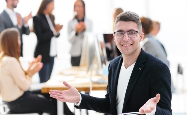 Gelukkige zakenman die dichtbij zijn bureau zit