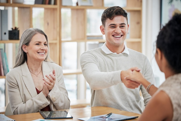 Foto gelukkige zakenmensen die handen schudden ontmoeten en begroeten in een kantoor gelukkige professional praat met zijn baas over een promotie of baan hr feliciteert ambitieuze werknemer die klapt en viert