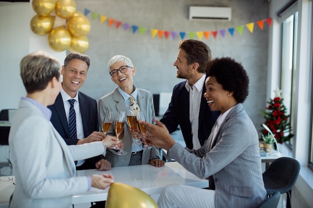 Gelukkige zakenmensen vieren en roosteren met champagne op een feestje