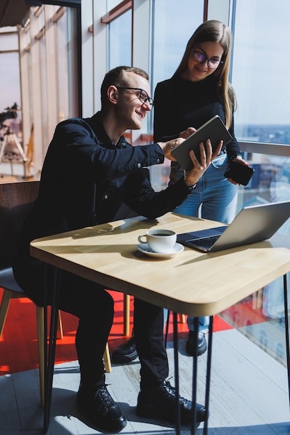 Gelukkige zakenmensen zitten aan tafel praten lachend bespreken zakelijke documenten lachende collega's werken samen op kantoor tijdens een briefing brainstormen op een vergadering