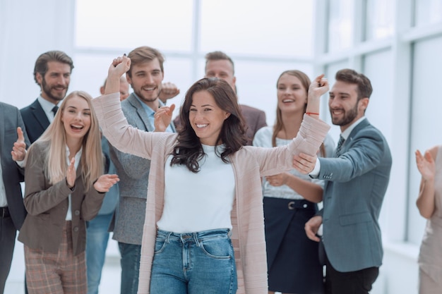 Gelukkige zakenvrouw die voor haar team staat