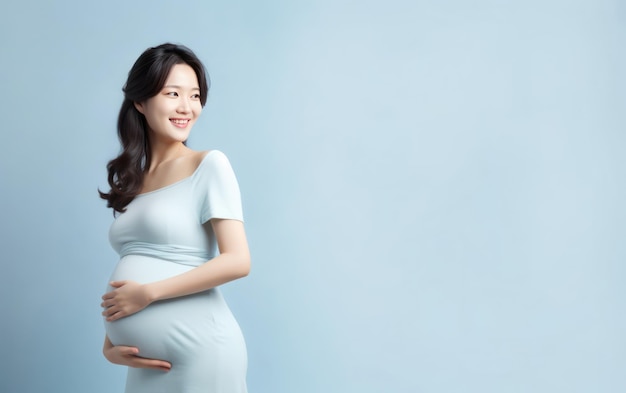 gelukkige zwangere aziatische vrouw die haar buik aanraakt