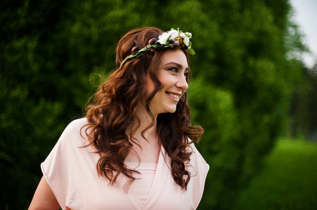 Gelukkige zwangere vrouw die op het groene gebied in park bij zonsopgang loopt