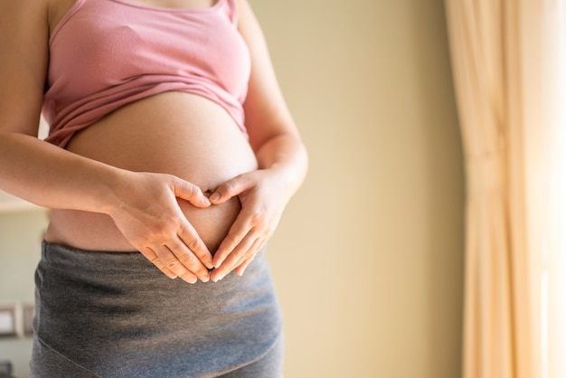 Gelukkige zwangere vrouw met baby in zwangere buik. kraamzorg en zwangerschap bij vrouwen.