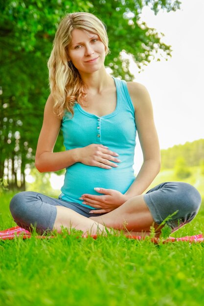 Gelukkige zwangere vrouw met een man in een park aan de natuur