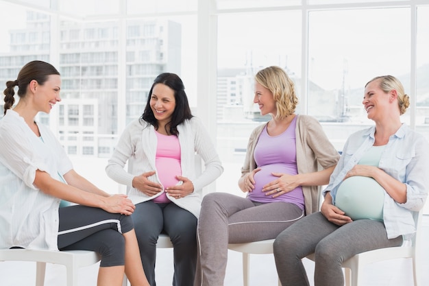 Gelukkige zwangere vrouwen die samen bij prenatale klasse spreken