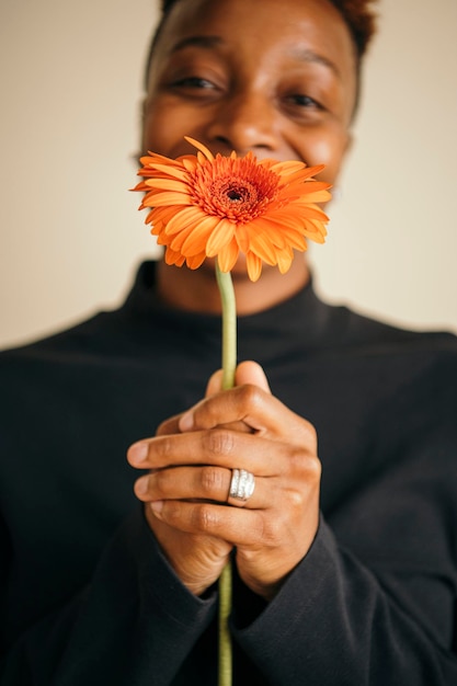 Gelukkige zwarte vrouw met een madeliefjebloem